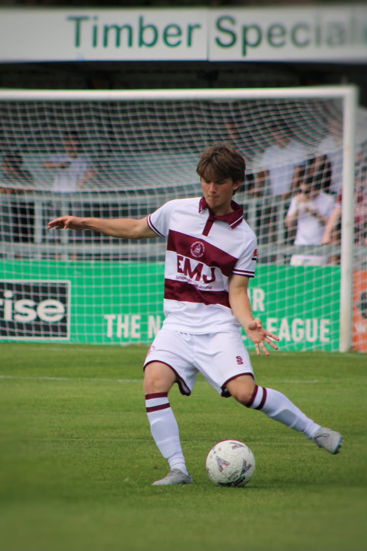 Football player striking the ball during a match