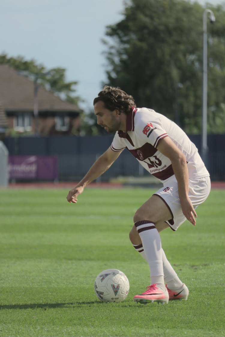 Football player controlling the ball in warm sunlight